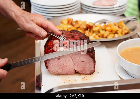 Koch ist Schneiden Beefsteak mit schinkenmesser von der Guest Relation Stockfoto