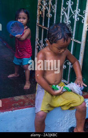 Ein Kind spielt während des Higantes-Festivals in Angono Philippinen mit Wasser Stockfoto