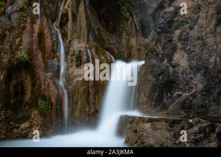 Lange Aufnahme eines Wasserfalls in den Felsen Stockfoto