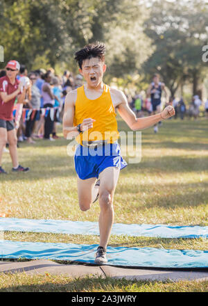 Asiatische High School Querfeldeinläufer kreuze Finish Line emotionale Stockfoto