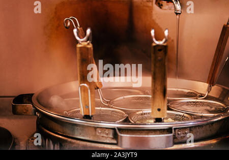 Hot Pot kochen Ramen mit Nudel Siebe und Dampf Nahaufnahme von Ramen noodle Restaurant mit warmen Ton Licht. Selektiver Fokus Stockfoto