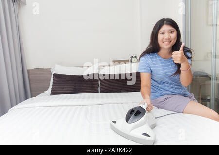 Mädchen Mädchen Reinigung Schlafzimmer mit Bett Vakuum zu saubere Matratzen für gute Gesundheit Allergie von Hausstaubmilben Schutz Stockfoto