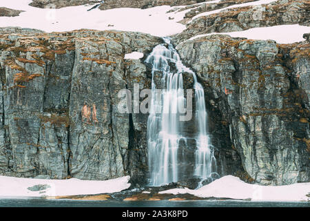 Straße Aurlandsfjellet, Norwegen. Wasserfall Flotvatnet im Frühjahr verschneiten Landschaft. Scenic Route Straße im Sommer norwegischen Landschaft. Natürliche norwegische Landm Stockfoto