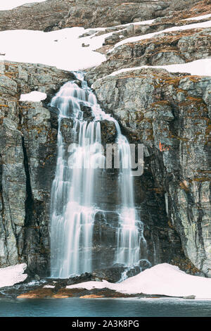 Straße Aurlandsfjellet, Norwegen. Wasserfall Flotvatnet im Frühjahr verschneiten Landschaft. Scenic Route Straße im Sommer norwegischen Landschaft. Natürliche norwegische Landm Stockfoto