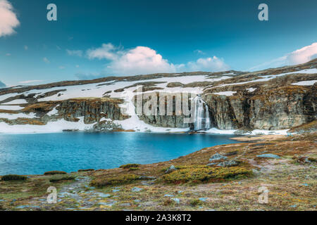 Straße Aurlandsfjellet, Norwegen. Wasserfall Flotvatnet im Frühjahr verschneiten Landschaft. Scenic Route Straße im Sommer norwegischen Landschaft. Natürliche norwegische Landm Stockfoto