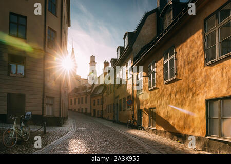 Stockholm, Schweden. Sonne Sonnenuntergang über traditionelle Stockholmer Straße. Schönen Strasse im sonnigen Sommerabend. Gemütliche Seitenstraße. Stockfoto