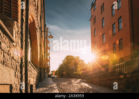 Stockholm, Schweden. Sonne Sonnenuntergang über Stockholm Straße. Schönen Straße mit mehrstöckigen Haus im sonnigen Sommerabend. Gemütliche Seitenstraße. Stockfoto