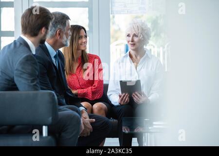 Team von Fachleuten in zwangloser Diskussion im Amt. Führungskräfte in freundliche Diskussion während der Pause. Stockfoto