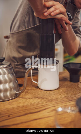 Barista drücken Kaffee in einem aeropress. Alternative Methode. Stockfoto