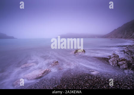 Eine neblige Dämmerung am Lulworth Cove, Jurassic Coast, Dorset, England, Stockfoto