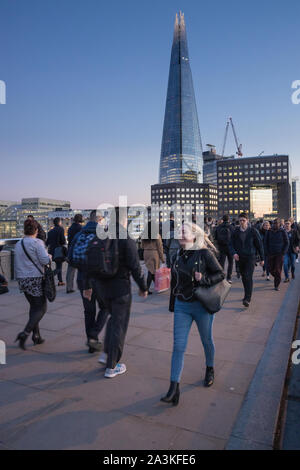 Pendler auf die London Bridge in der Dämmerung, mit dem Shard jenseits, London, England, Großbritannien Stockfoto