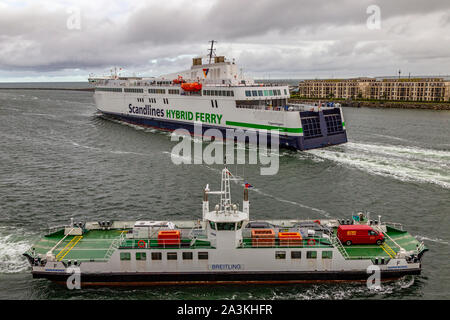 Hybrid Scandlines Fähre aus dem Hafen und der Fähre über den Fluss in Warnemünde, Deutschland. Stockfoto