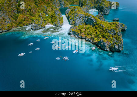 Luftaufnahme von erstaunlichen Mililoc Insel. Touristische boote in der Nähe der grossen Lagune. El Nido, Palawan, Philippinen. Surreale karst Kalkstein Felsen Stockfoto