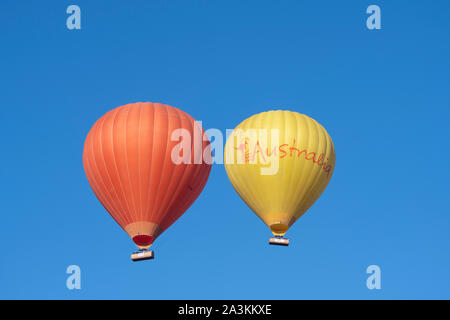 Eine orange und eine gelbe Heißluftballon im Flug, Mareeba, Far North Queensland, FNQ, QLD, Australien Stockfoto