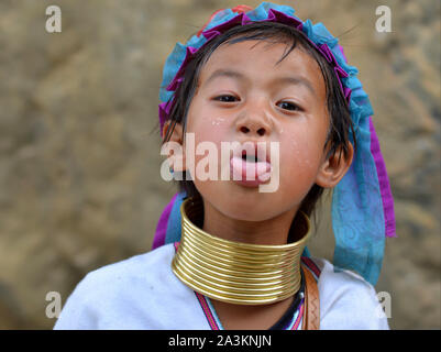Wenig Myanmarese Kayan Lahwi Mädchen mit Tribal messing Gewindehälften/Spulen klebt die Zunge heraus. Stockfoto