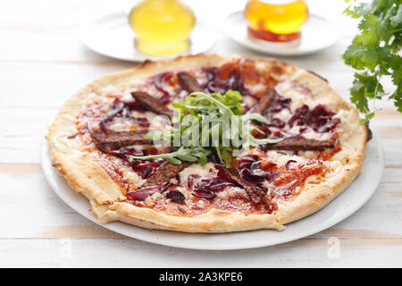 Vegane Pizza mit Tomatensauce, geräucherte Tempeh und roten Zwiebeln. Stockfoto