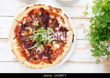 Vegetarische Pizza mit Tomatensauce, geräucherte Tempeh und roten Zwiebeln. Stockfoto