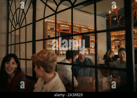 Junge Menschen sprechen über Getränke an der Bar in der Nacht Stockfoto
