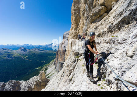 Mehrere junge Bergsteiger auf sehr exponierten Klettersteig in Alta Badia in den Dolomiten Stockfoto