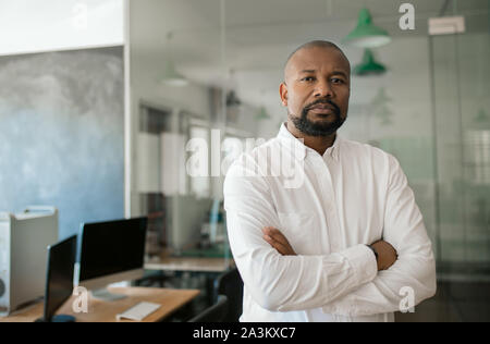 Reifen Afrikanische amerikanische Geschäftsmann allein in einem großen Büro Stockfoto