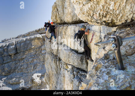 Mehrere junge Bergsteiger auf sehr exponierten Klettersteig in Alta Badia in den Dolomiten Stockfoto