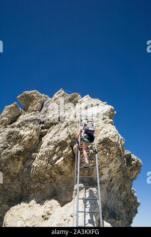 Attraktive Blondine weiblichen Bergsteiger auf einem steilen Klettersteig in Südtirol Stockfoto