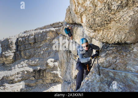 Zwei junge Bergsteiger auf sehr exponierten Klettersteig in Alta Badia in den Dolomiten Stockfoto