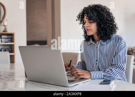 Junge weibliche Unternehmer arbeiten zu Hause auf Ihrem Laptop Stockfoto