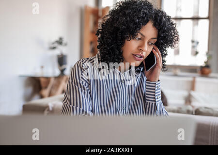 Junge weibliche Unternehmer im Gespräch mit einem Client auf Ihrem Handy Stockfoto