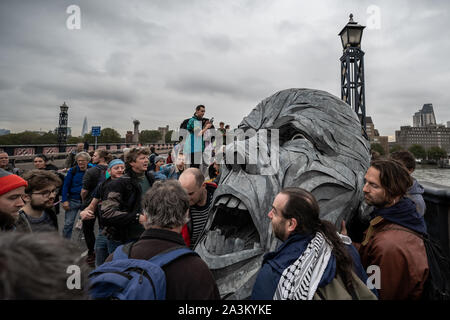 London, Großbritannien. 7 Okt, 2019. Körperteile eines riesigen metallischen Abbildung sind in Position vom Aussterben Rebellion Demonstranten während einer Besetzung der Lambeth Brücke verschoben. Die Umweltaktivisten beginnen Sie eine neue Welle von Protest Aktion heute Morgen verursachen Störungen in London. Der Metropolitan Police bestätigt 21 Verhaftungen so weit heute Morgen. Credit: Guy Corbishley/Alamy leben Nachrichten Stockfoto