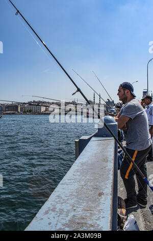 Istanbul: Skyline der Stadt und die lokalen Fischer mit ihren Angel auf der Galata Brücke, die Brücke über das Goldene Horn und den Bosporus. Stockfoto