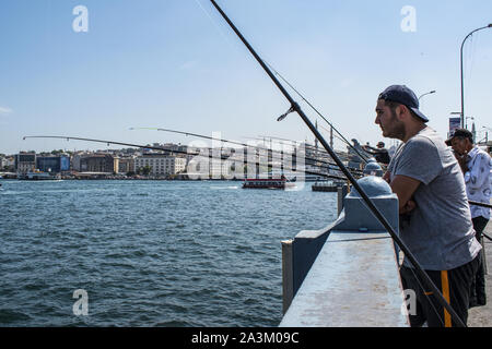 Istanbul: Skyline der Stadt und die lokalen Fischer mit ihren Angel auf der Galata Brücke, die Brücke über das Goldene Horn und den Bosporus. Stockfoto