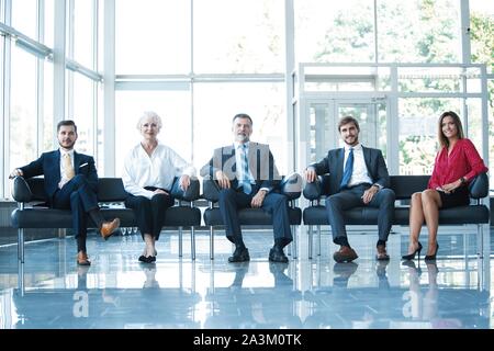 Zuversichtlich Business Team sitzen auf Stühlen in einer Reihe. Stockfoto