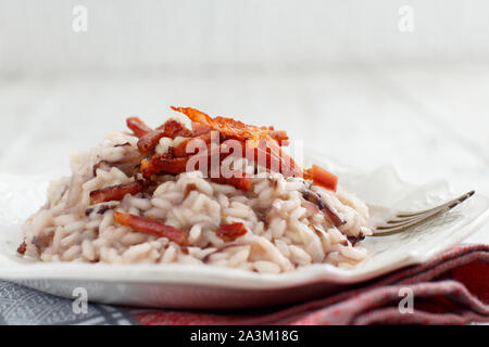 Risotto mit rotem Radicchio und knusprigem Speck (Speck) Nahaufnahme Stockfoto