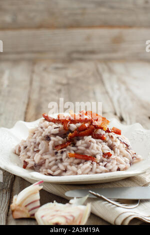 Risotto mit rotem Radicchio und knusprigem Speck (Speck) Nahaufnahme Stockfoto