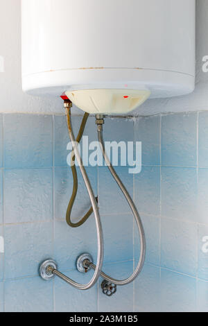 Angeschlossene elektrische Wasserboiler oder Heizung an der Wand im Badezimmer Stockfoto