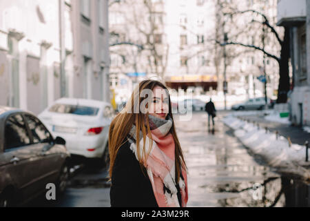 Junge Frau trägt warme Kleidung auf der Straße im Winter Stockfoto