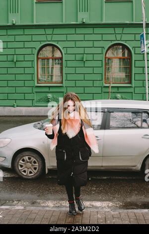 Glückliche junge Frau in warme Kleidung Kreuzung Straße der Stadt im Winter Stockfoto