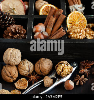 Eine Kiste voller Gewürze und Nüsse auf einem Holztisch, Ansicht von oben Stockfoto