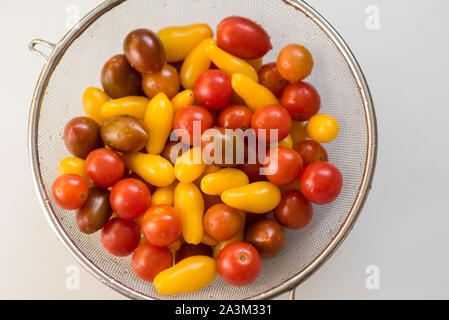 Sauber, frisch, gewaschene Bunte Cherry Tomaten in einem Sieb. Wassertropfen auf Gemüse. Wichtig Gemüse vor dem Verzehr zu waschen. Stockfoto