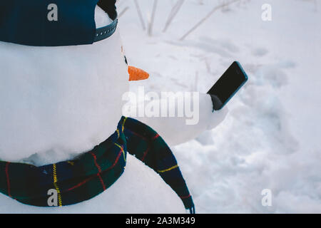 Schneemann mit smart phone Stockfoto