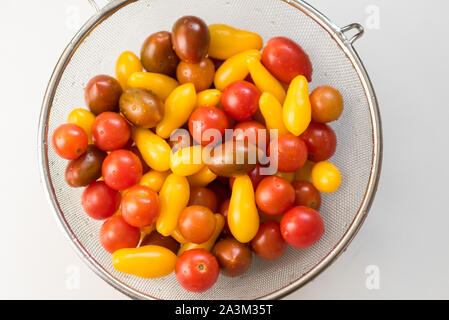 Sauber, frisch, gewaschene Bunte Cherry Tomaten in einem Sieb. Wassertropfen auf Gemüse. Wichtig Gemüse vor dem Verzehr zu waschen. Stockfoto