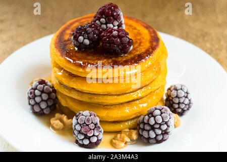 Kürbis Pfannkuchen mit Ahornsirup, Beeren und Nüsse. Am Ende der Saison (Herbst) Frühstück. Stockfoto