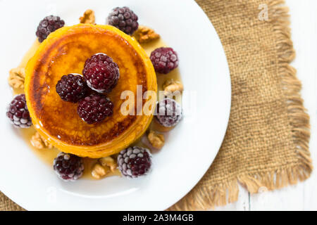 Kürbis Pfannkuchen mit Ahornsirup, Beeren und Nüsse. Am Ende der Saison (Herbst) Frühstück. Ansicht von oben. Stockfoto