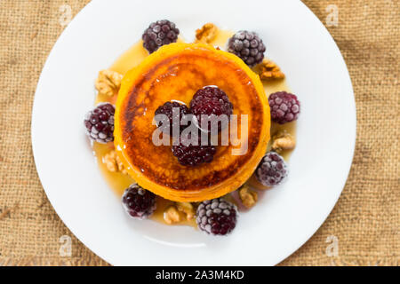 Kürbis Pfannkuchen mit Ahornsirup, Beeren und Nüsse. Am Ende der Saison (Herbst) Frühstück. Ansicht von oben. Stockfoto