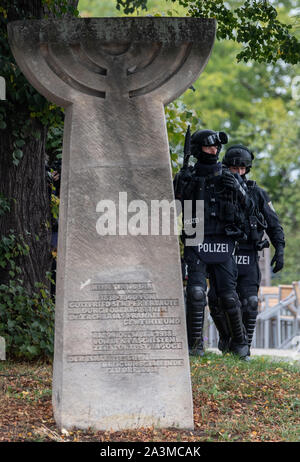 Dresden, Deutschland. 09 Okt, 2019. Polizisten stehen hinter dem Denkmal zur Erinnerung an die Pogromnacht im November 1938 und gegenüber der Synagoge in Dresden bewaffnet. Nach ersten Erkenntnissen wurden zwei Menschen in den Schüssen in Halle feuerte getötet. Schüsse wurden auch in Landsberg (saalekreis) abgefeuert. Credit: Robert Michael/dpa-Zentralbild/dpa/Alamy leben Nachrichten Stockfoto