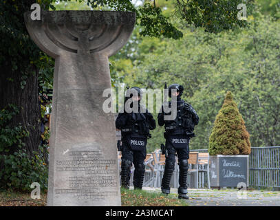 Dresden, Deutschland. 09 Okt, 2019. Polizisten stehen hinter dem Denkmal zur Erinnerung an die Pogromnacht im November 1938 und gegenüber der Synagoge in Dresden bewaffnet. Nach ersten Erkenntnissen wurden zwei Menschen in den Schüssen in Halle feuerte getötet. Schüsse wurden auch in Landsberg (saalekreis) abgefeuert. Credit: Robert Michael/dpa-Zentralbild/dpa/Alamy leben Nachrichten Stockfoto