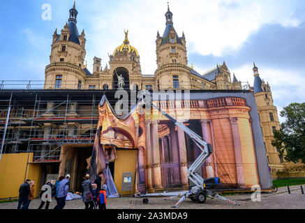 Schwerin, Deutschland. 09 Okt, 2019. Arbeitnehmer an eine schützende Plane mit den lackierten Eingangsbereich zum Portal vor das Schweriner Schloss. Teile des Schlosses müssen für Renovierungsarbeiten eingerüstet werden. Credit: Jens Büttner/dpa-Zentralbild/dpa/Alamy leben Nachrichten Stockfoto