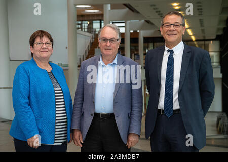 Ulm, Deutschland. 09 Okt, 2019. Der Chemiker Stanley Whittingham (M) auf einem internationalen Kongress, Batterie neben Margret Wohlfahrt-Mehrens (l), Leiter der Forschung bei der Batterie das Ulmer Zentrum für Sonnenenergie- und Wasserstoff-Forschung Baden-Württemberg (ZSW) und Stefano Passerini, Direktor der Elektrochemie am Helmholtz Institut Ulm. Whittingham hat Nobelpreisträger für Chemie 2019 genannt worden. Quelle: dpa Picture alliance/Alamy leben Nachrichten Stockfoto