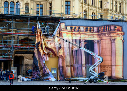 Schwerin, Deutschland. 09 Okt, 2019. Arbeitnehmer an eine schützende Plane mit den lackierten Eingangsbereich zum Portal vor das Schweriner Schloss. Teile des Schlosses müssen für Renovierungsarbeiten eingerüstet werden. Credit: Jens Büttner/dpa-Zentralbild/dpa/Alamy leben Nachrichten Stockfoto